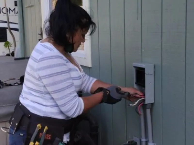 Licensed electrician wiring an exterior subpanel in Grain Valley